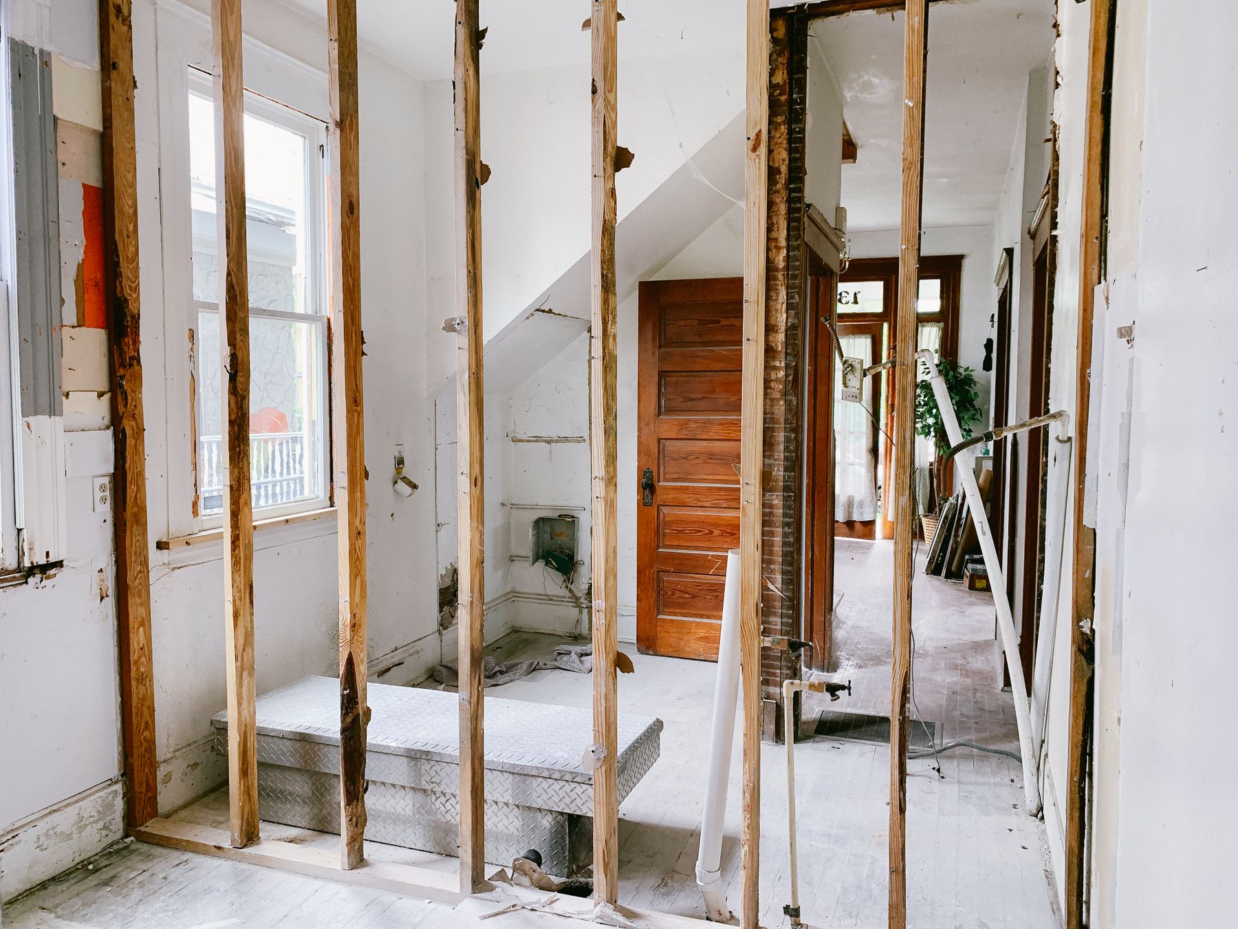 Home interior under renovation with exposed wooden framing and unfinished walls