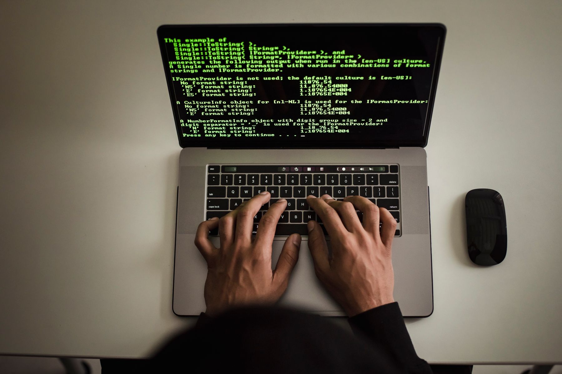 Hands working on a laptop with code on screen